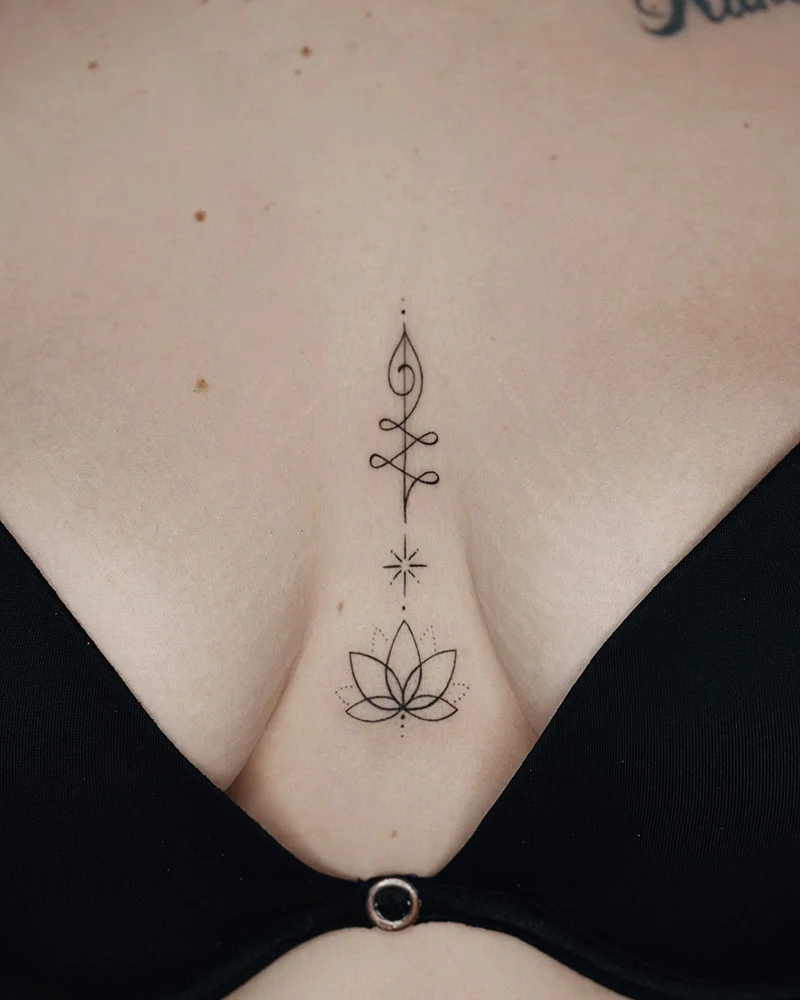 Tatuaje de línea fina inspirado en la flor de loto y ubicado en el pecho.
